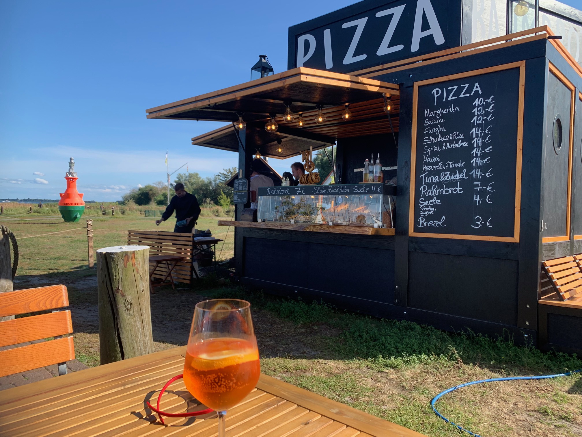 in der Sommersaison steht ein Pizzawagen im Hafen